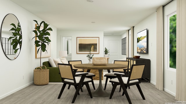 dining space featuring light wood-style flooring and baseboards