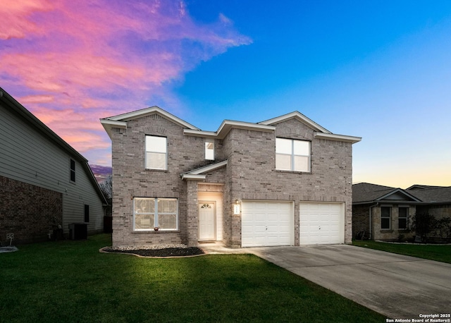 traditional home featuring a yard, concrete driveway, brick siding, and an attached garage