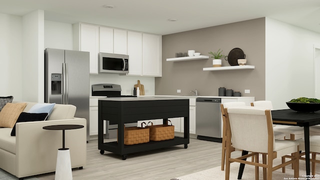 kitchen with white cabinets, light wood-style floors, stainless steel appliances, and light countertops