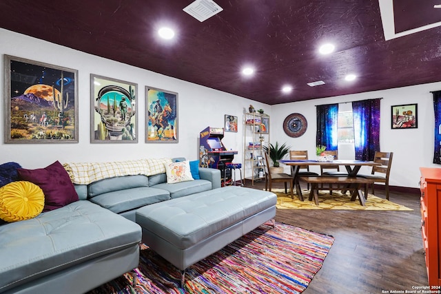 living room featuring baseboards, visible vents, wood finished floors, and recessed lighting