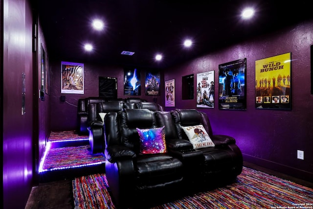 home theater featuring a textured wall, visible vents, and recessed lighting