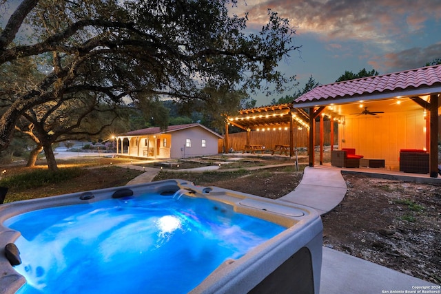 view of swimming pool featuring a patio, an outdoor hot tub, an outdoor hangout area, ceiling fan, and an outdoor structure