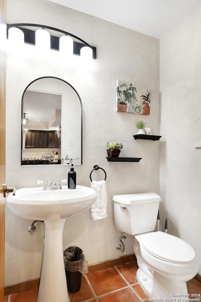 bathroom featuring toilet, tile patterned flooring, and baseboards