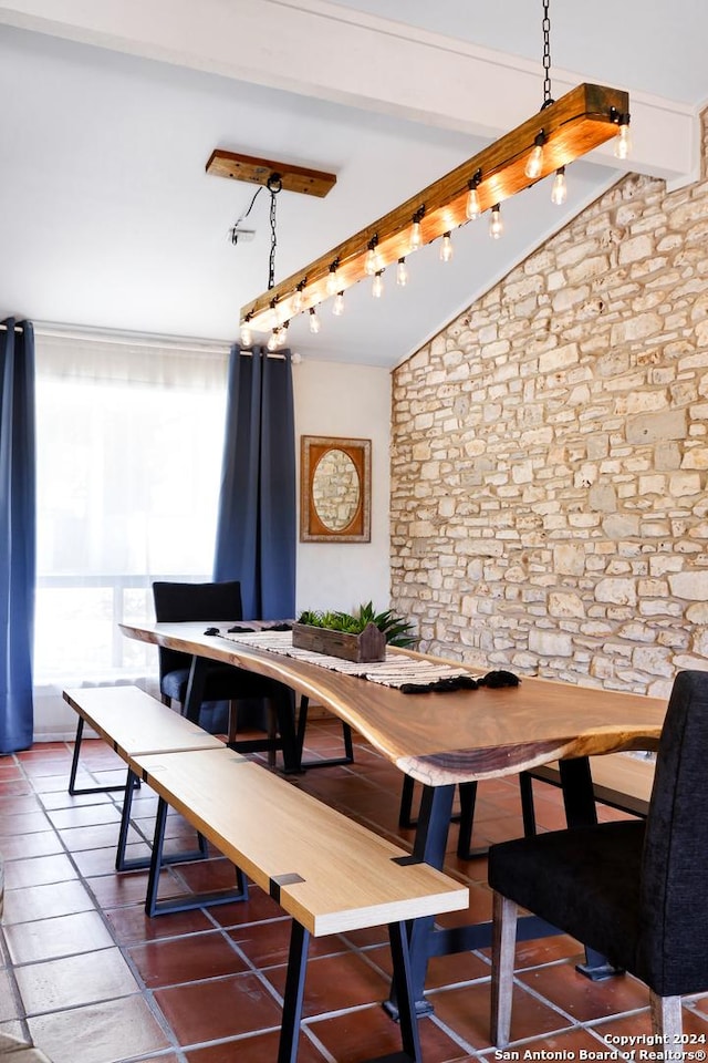 dining area featuring vaulted ceiling with beams