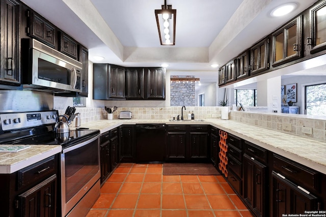 kitchen with light countertops, appliances with stainless steel finishes, and a tray ceiling