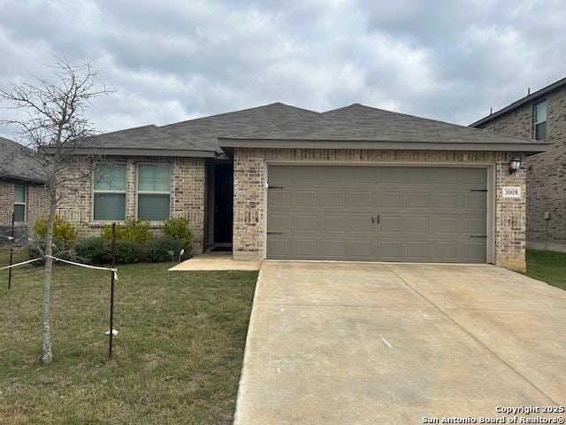 ranch-style home with a garage, brick siding, concrete driveway, and a front yard