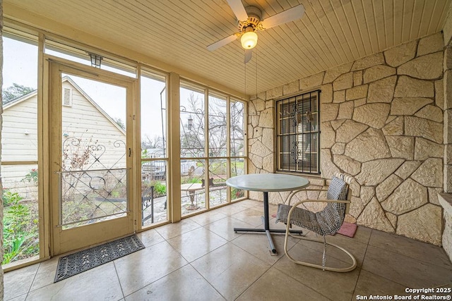 sunroom featuring a healthy amount of sunlight, wooden ceiling, and ceiling fan