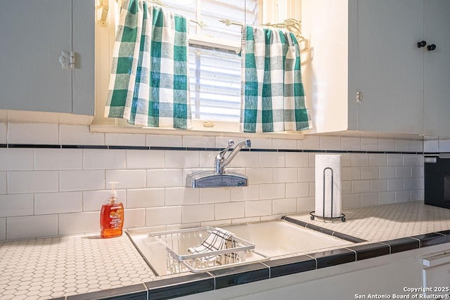 kitchen featuring light countertops, a sink, and backsplash