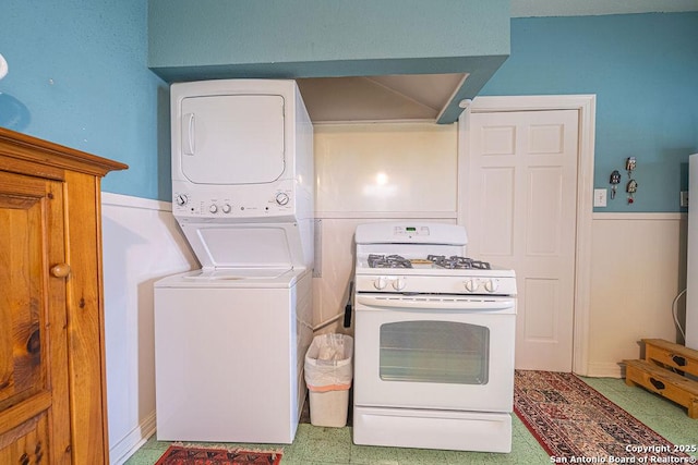 interior space with white gas range oven and stacked washer / drying machine