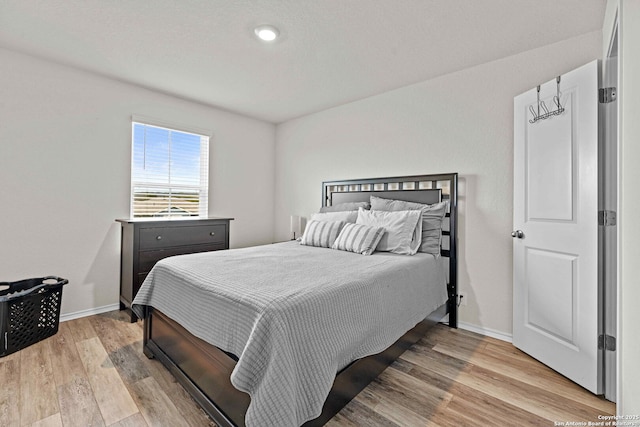 bedroom with light wood-style flooring and baseboards