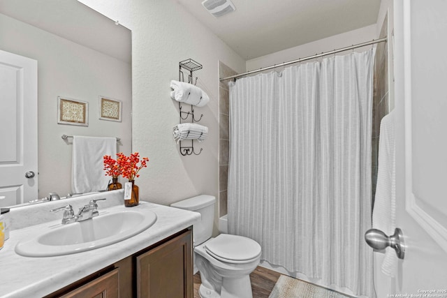 bathroom featuring visible vents, vanity, toilet, and wood finished floors