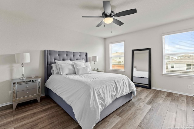 bedroom featuring multiple windows, wood finished floors, and baseboards