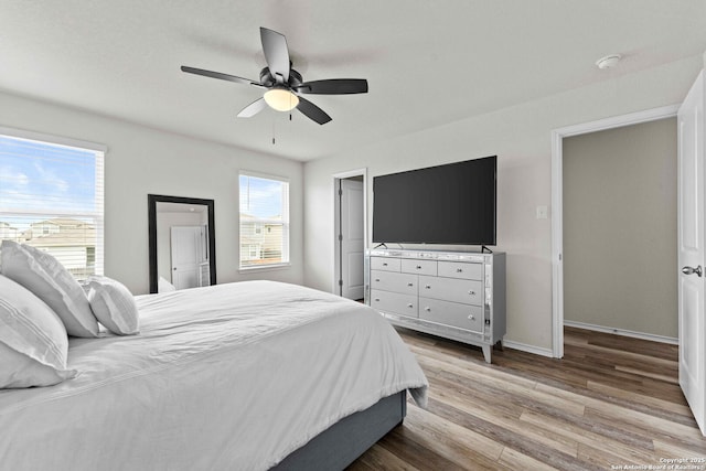 bedroom with light wood-style floors, ceiling fan, and baseboards