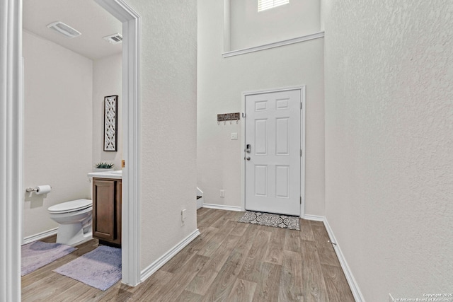 interior space with light wood-style floors, baseboards, and visible vents