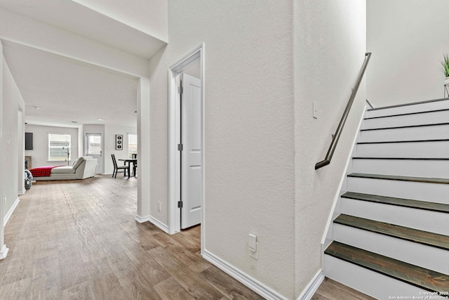 stairway with baseboards and wood finished floors