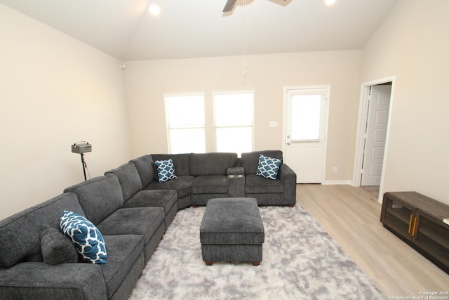 living area featuring vaulted ceiling, light wood-style flooring, baseboards, and ceiling fan