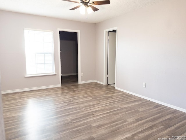 unfurnished room featuring ceiling fan, a textured ceiling, wood finished floors, and baseboards