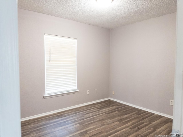 spare room with dark wood-style floors, baseboards, and a textured ceiling