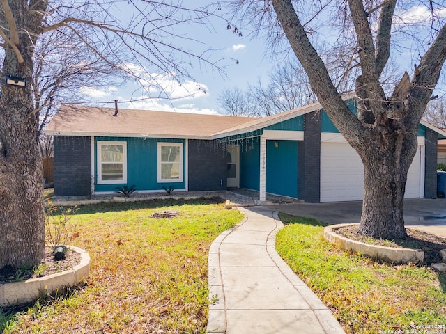 view of front of house featuring a front lawn, brick siding, driveway, and an attached garage