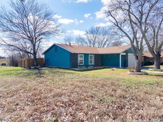 single story home with an attached garage and a front yard