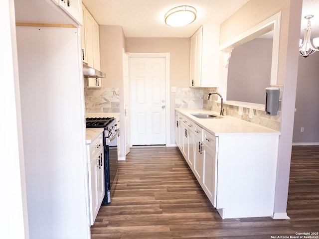 kitchen featuring a sink, gas range, and white cabinets