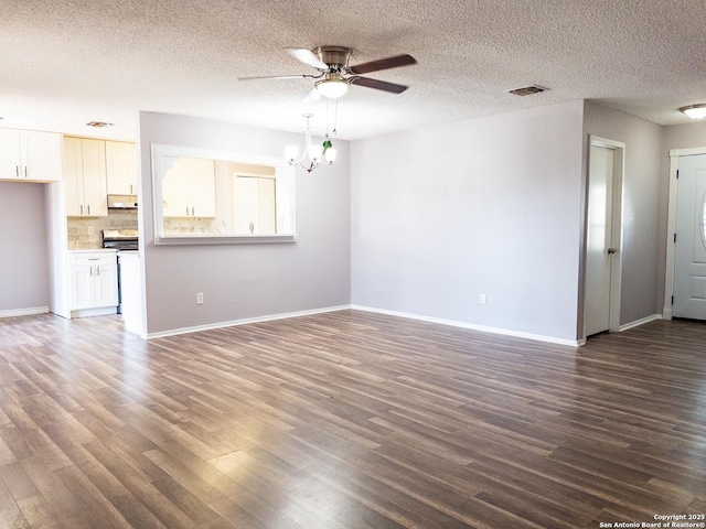 unfurnished living room with dark wood-style flooring, visible vents, a textured ceiling, baseboards, and ceiling fan with notable chandelier