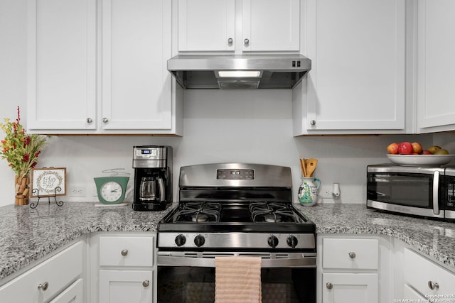 kitchen with appliances with stainless steel finishes, white cabinets, light stone counters, and ventilation hood