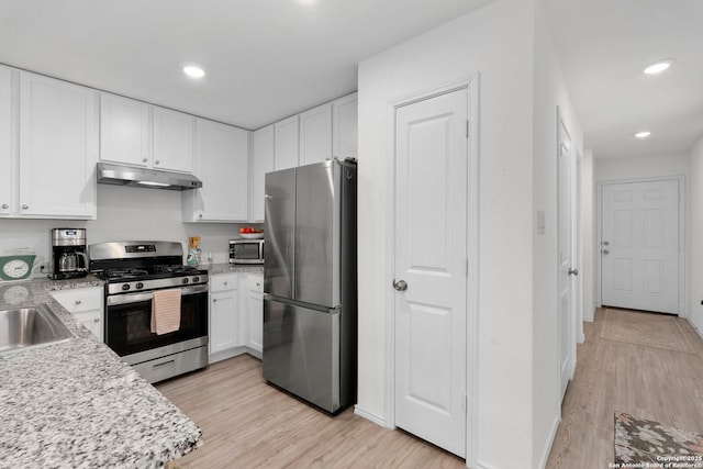 kitchen with recessed lighting, under cabinet range hood, stainless steel appliances, white cabinetry, and light wood-style floors