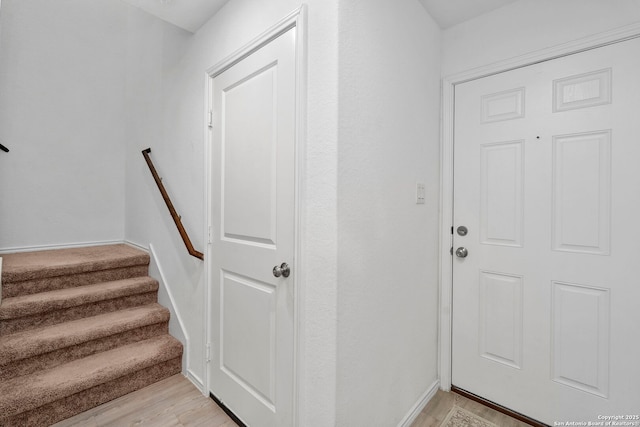 stairway featuring baseboards and wood finished floors