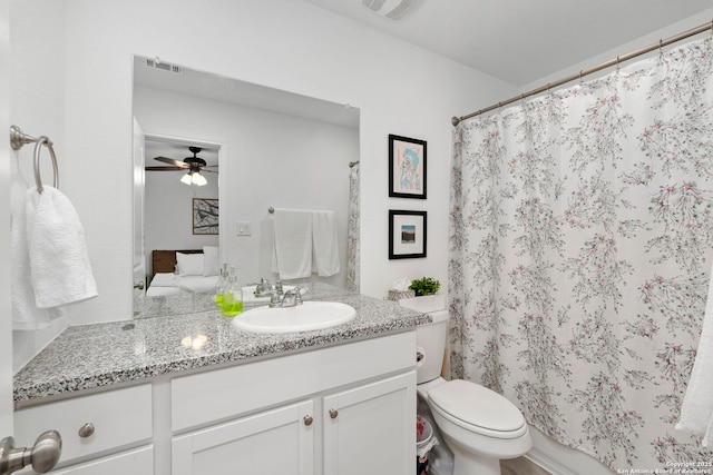 bathroom with toilet, visible vents, vanity, and a ceiling fan