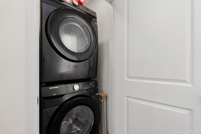 clothes washing area featuring laundry area and stacked washing maching and dryer