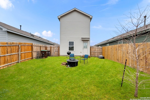 back of house featuring a fenced backyard and a lawn