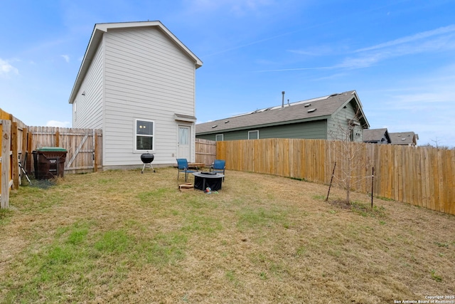 back of property featuring a fenced backyard and a yard