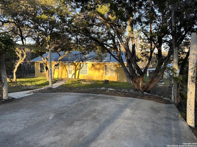 ranch-style home featuring driveway and a front lawn