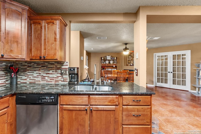 kitchen featuring dark stone counters, a sink, visible vents, french doors, and dishwasher