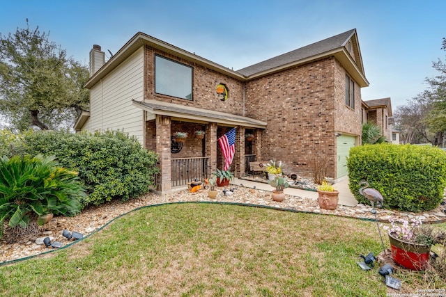 traditional-style home featuring brick siding, a chimney, an attached garage, covered porch, and a front yard