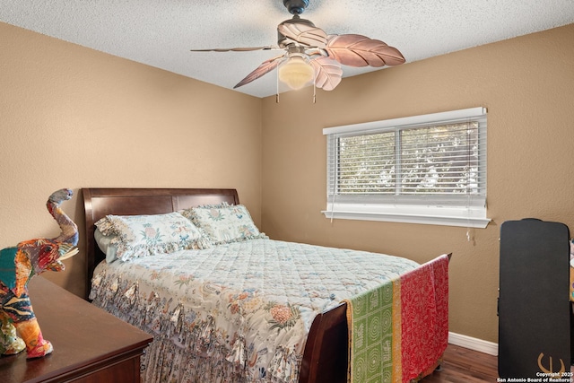 bedroom featuring dark wood-style floors, ceiling fan, a textured ceiling, and baseboards