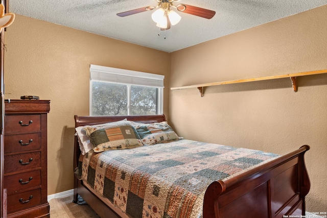 bedroom with light colored carpet, a textured wall, a ceiling fan, a textured ceiling, and baseboards