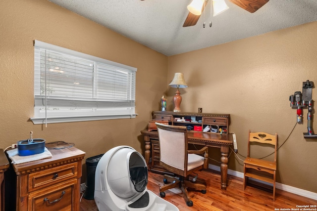 home office with baseboards, a textured ceiling, a ceiling fan, and light wood-style floors