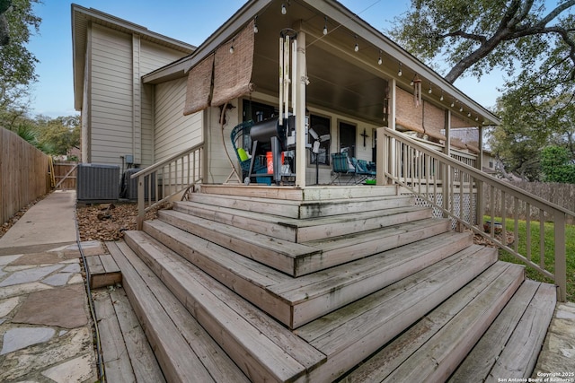 deck featuring fence private yard, central AC, and stairway