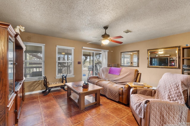 living area with visible vents, ceiling fan, a textured ceiling, baseboards, and tile patterned floors