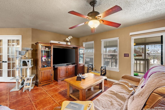 living area with a textured ceiling, a ceiling fan, french doors, and tile patterned floors