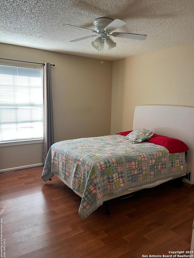 bedroom with a ceiling fan, dark wood-style flooring, and a textured ceiling