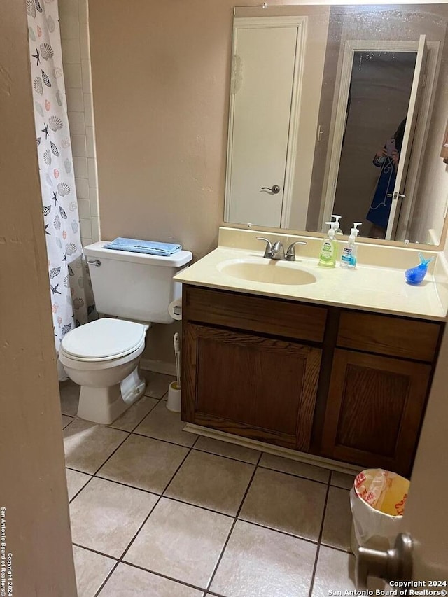 bathroom with toilet, tile patterned flooring, and vanity