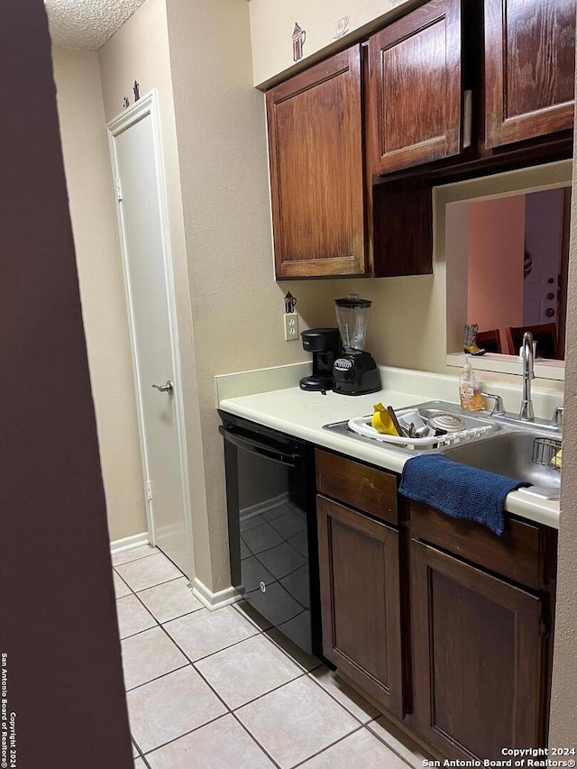 kitchen featuring black dishwasher, light countertops, light tile patterned floors, and dark brown cabinetry