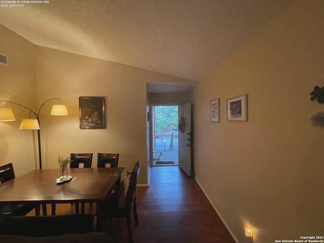 dining room with dark wood-style floors, visible vents, vaulted ceiling, and baseboards