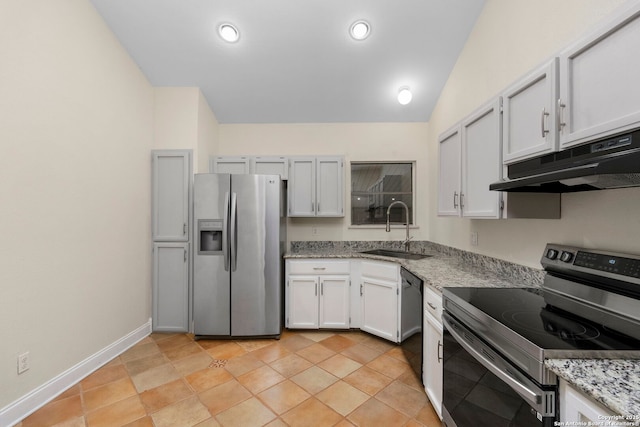 kitchen with light stone counters, under cabinet range hood, a sink, white cabinetry, and appliances with stainless steel finishes