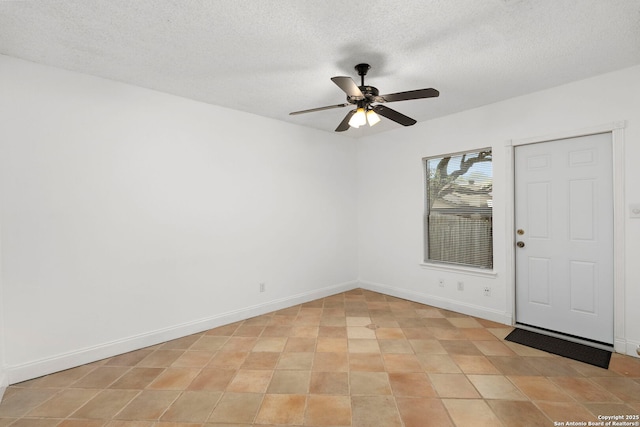 unfurnished room featuring a textured ceiling, a ceiling fan, and baseboards