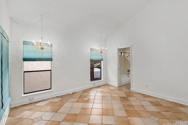 spare room with light tile patterned floors, a textured ceiling, a wealth of natural light, and a notable chandelier