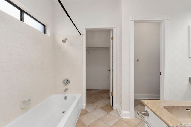 full bath featuring baseboards, bathing tub / shower combination, tile patterned floors, a spacious closet, and vanity